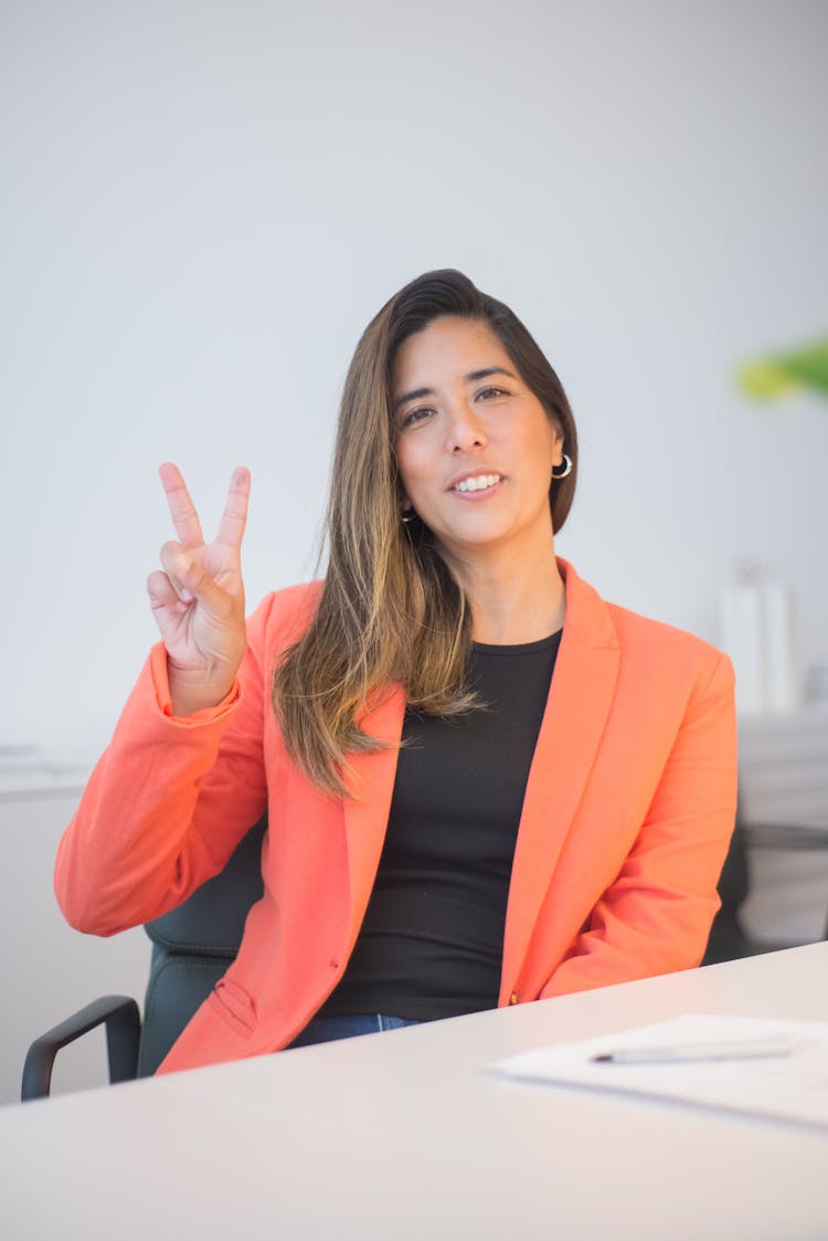 Woman Wearing Blazer Doing A Peace Sign