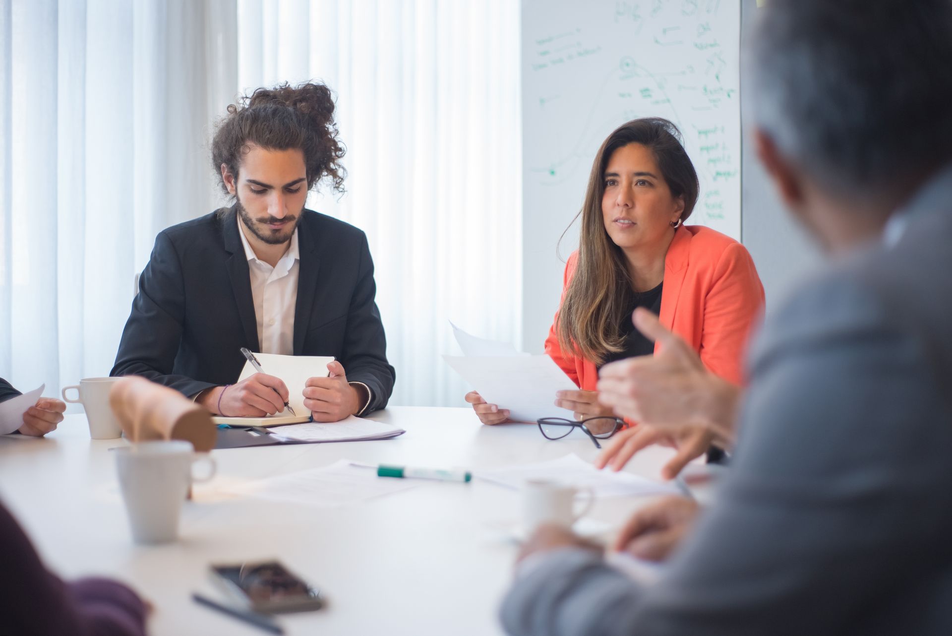 Focused business professionals engaged in a meeting in a contemporary office, fostering collaboration.