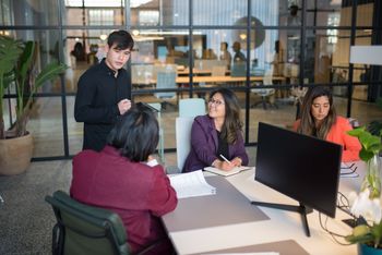 A team lead running a working session at a shared desk — photo by Kampus Production on Pexels