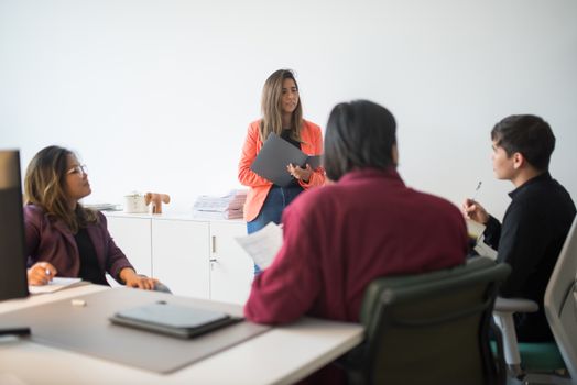 A diverse team in a modern office engaging in a collaborative business meeting.