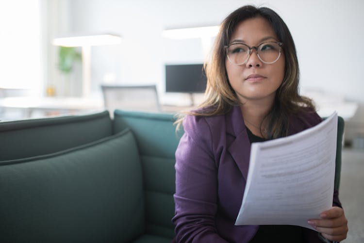 Woman Wearing Eyeglasses Holding A Document