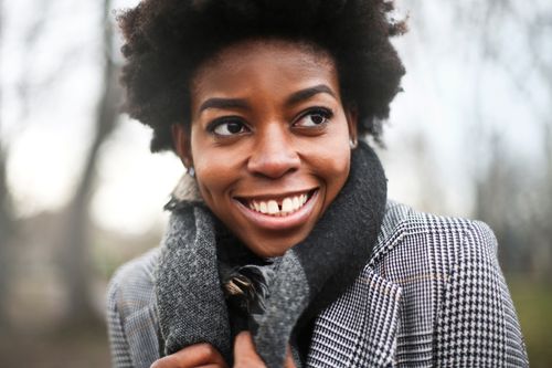 Free Portrait of a smiling woman in a scarf outdoors during autumn in Budapest. Stock Photo