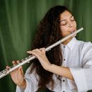 Woman in White Sweater Playing Flute