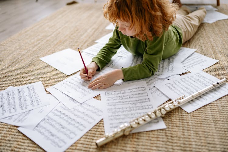 A Boy Writing On A Musical Notation