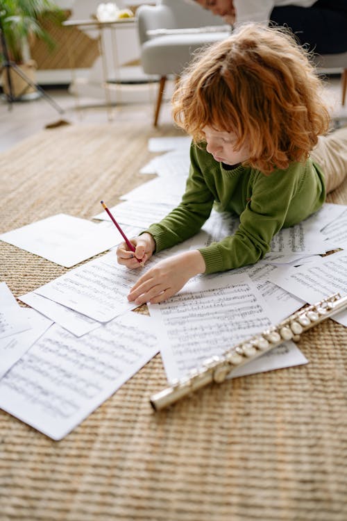 A Boy Writing on a Musical Notation