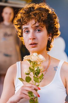 Emotional portrait of a woman holding yellow roses indoors, with soft focus background.
