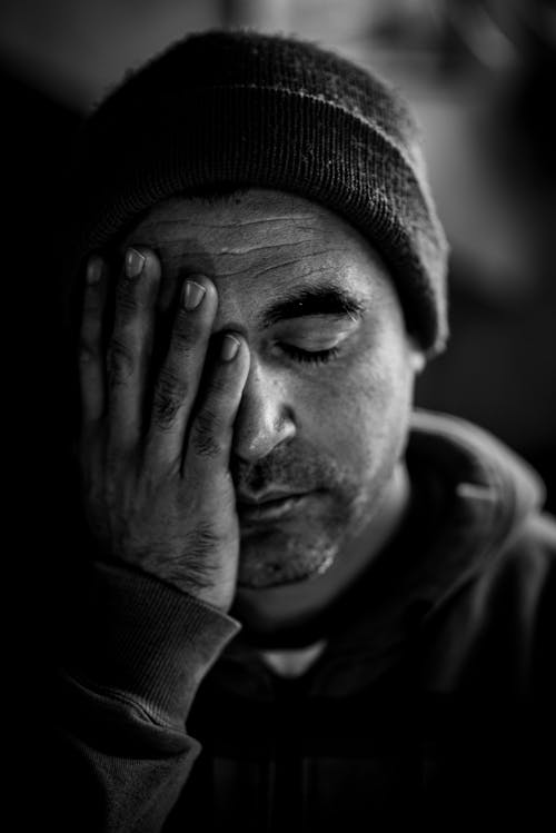 Free Man Holding His Face In Grayscale Photography Stock Photo