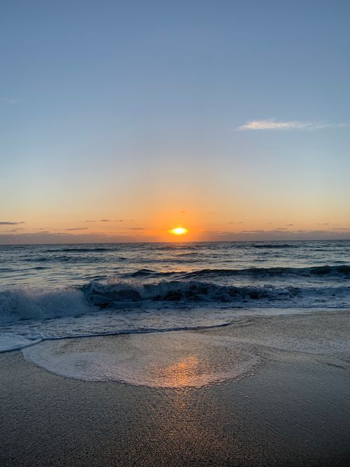 Free Experience the serene sunset at Jensen Beach with vibrant colors reflecting off the ocean waves. Stock Photo