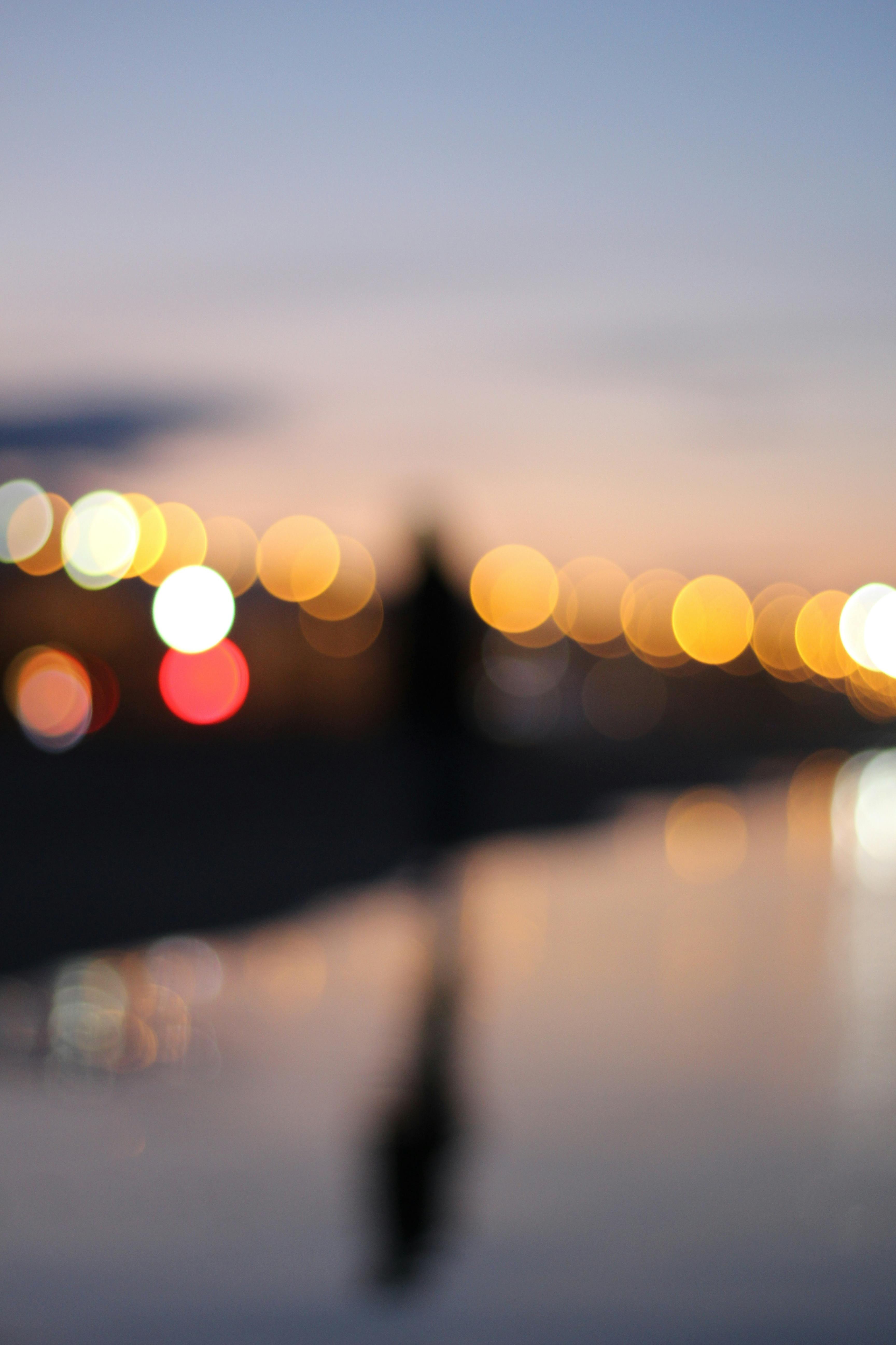 Blurry urban scene with warm bokeh lights creating an abstract dusk cityscape.