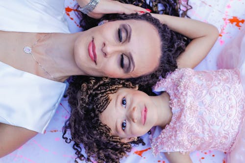 A Mother and Daughter Smiling while Lying Upside Down