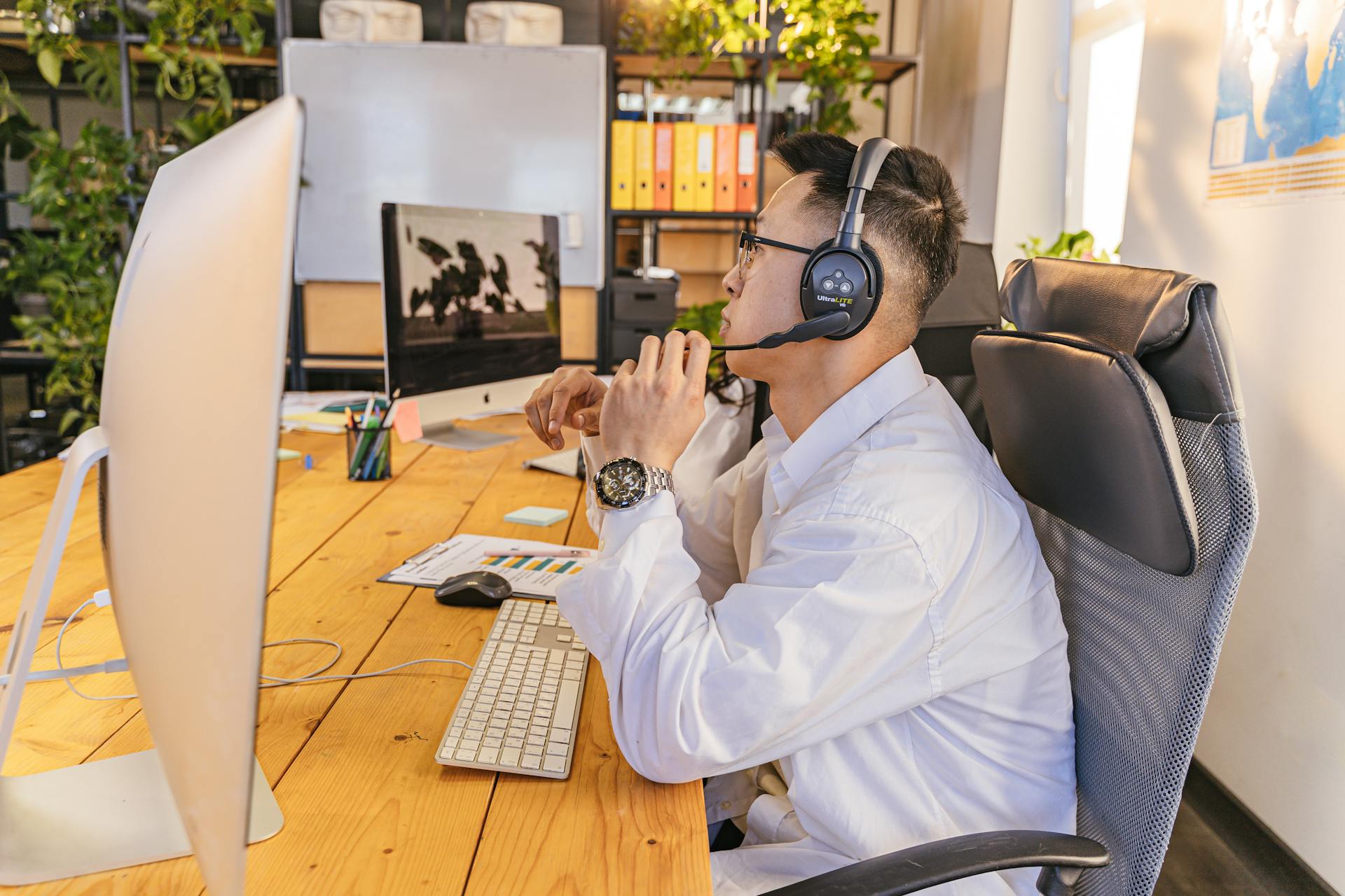 Business professional working with headset in a modern office setting.