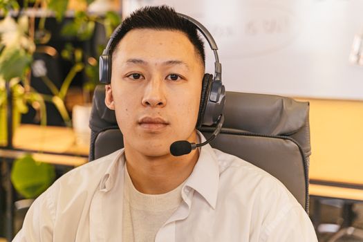 Focused young man with headset in a modern office setting.