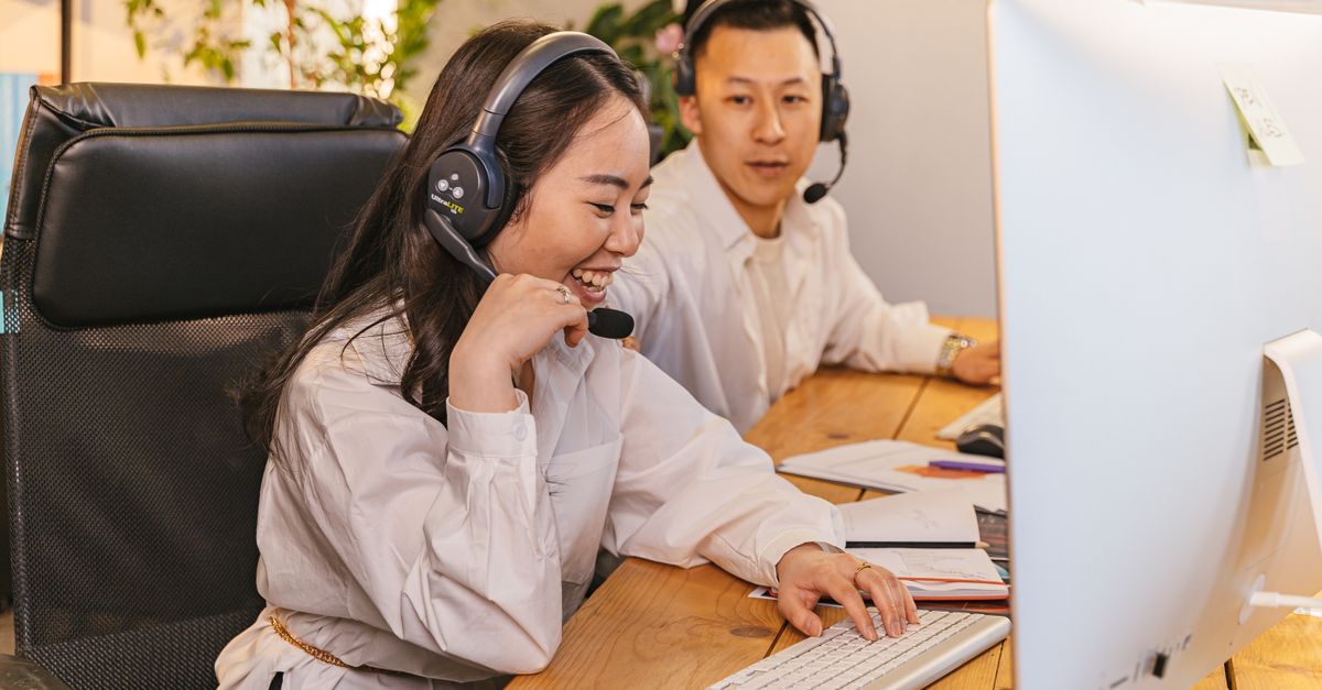 Photo by Antoni Shkraba Studio Two call center agents working together, focused and engaged at their desks, communicating via headsets.