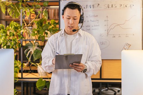 Man in White Long Sleeve Shirt Holding a Clipboard