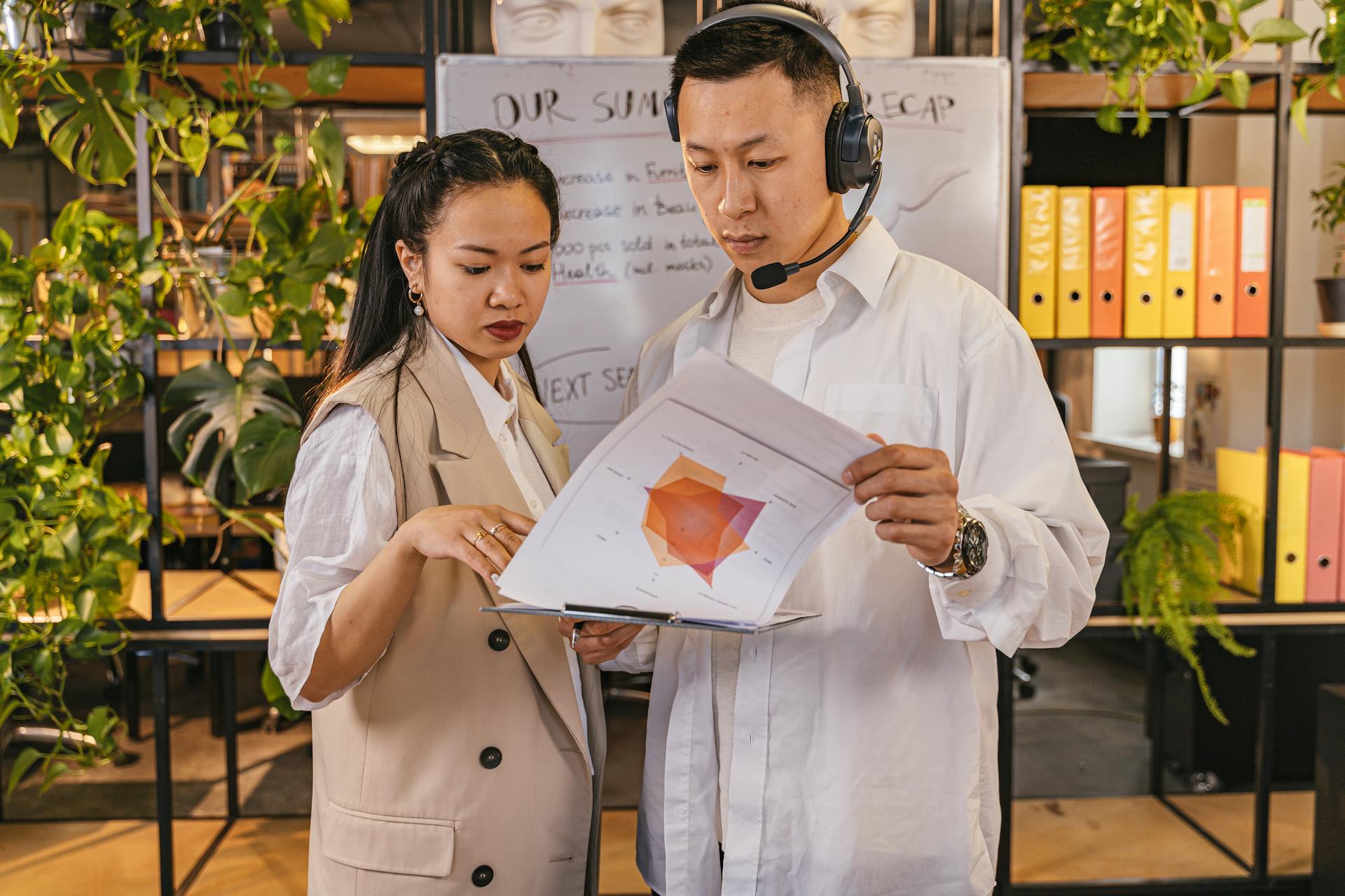 Colleagues Holding and Looking Report Papers