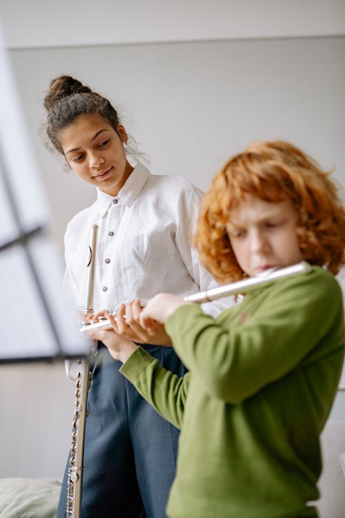 Free A child receives flute lessons from an instructor, captured during a music session indoors. Stock Photo