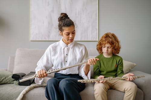 Free Child and Woman Sitting on a Sofa Holding Flutes Stock Photo