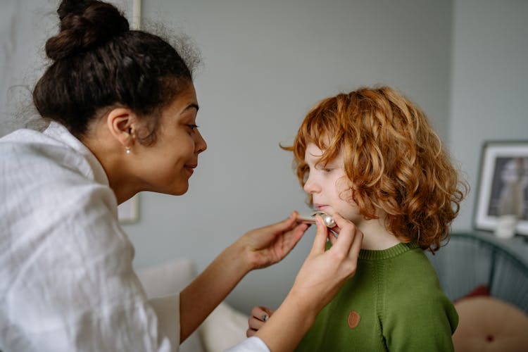 Woman Teaching A Kid To Play Flute