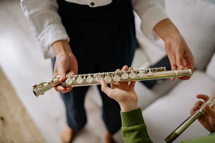 Person Handing A Flute To A Child