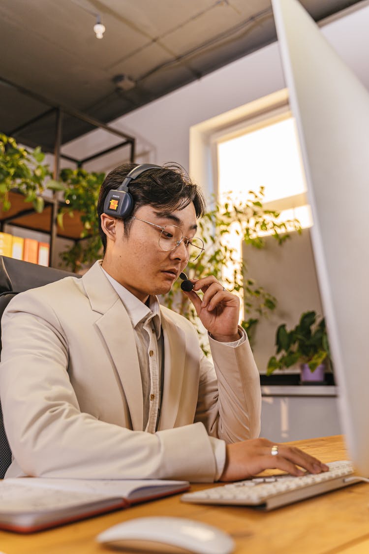 Man Answering Calls In Front Of Computer