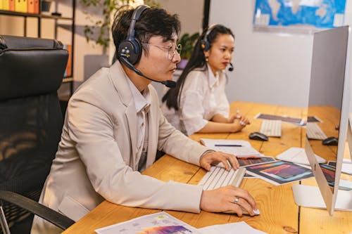 Man and Woman Wearing a Headset with a Microphone in an Office