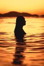 Silhouette of Woman in Water during Sunset