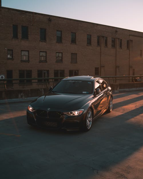 Free Black Bmw Car Parked Near Brown Building Stock Photo