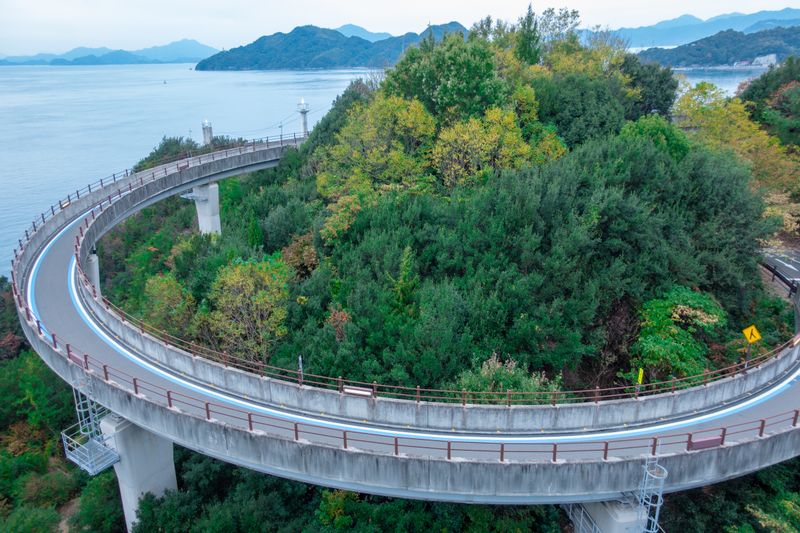 The Shimanami Kaido cycling route — the spiral approach bridge at Innoshima over the Seto Inland Sea connecting Hiroshima Prefecture to the island chain