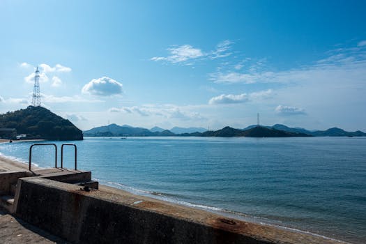 Tranquil view of the seaside embankment at Onomichi, Hiroshima with blue sky and islands.