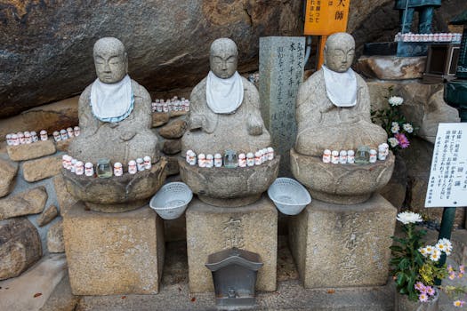 Sacred stone statues with offerings at Onomichi shrine, Hiroshima, Japan.
