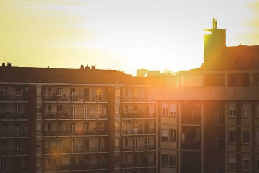 A serene view of the sunrise illuminating urban apartment buildings.