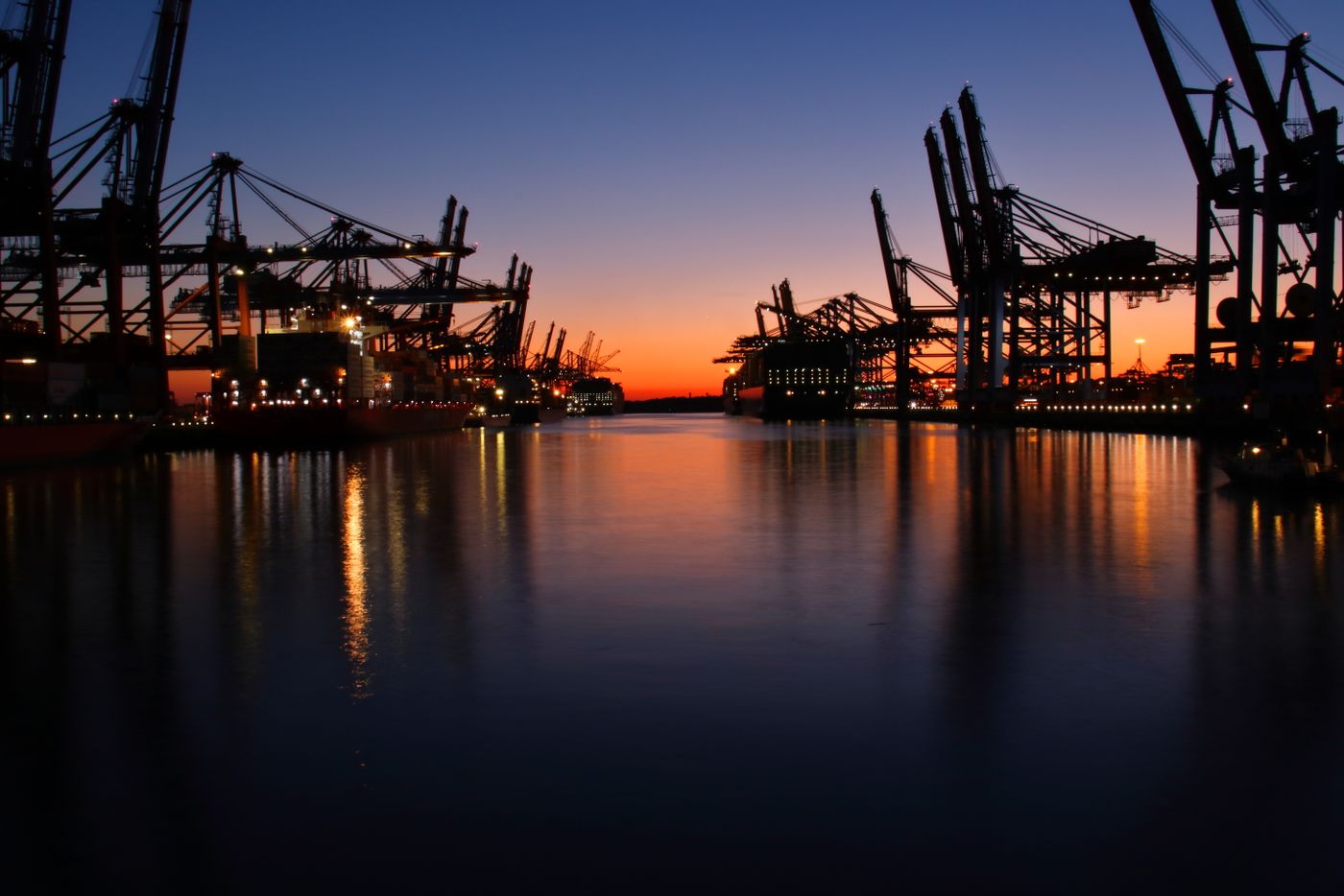Port cranes silhouetted at twilight