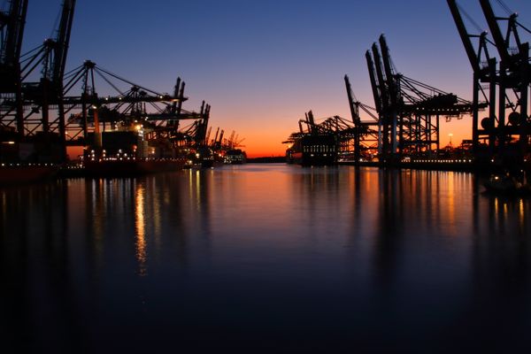 Port cranes silhouetted at twilight