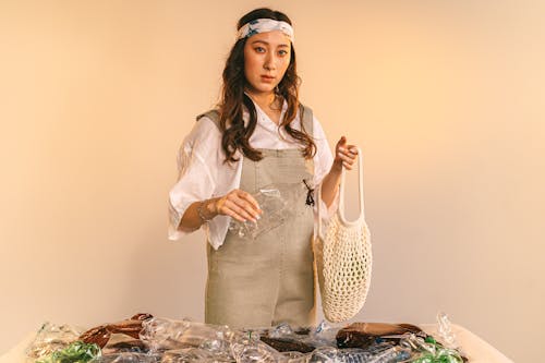 A Woman Holding a Plastic Bottle and a Mesh Bag