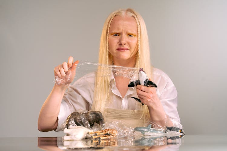 Albino Girl Unwrapping Toy Figurines