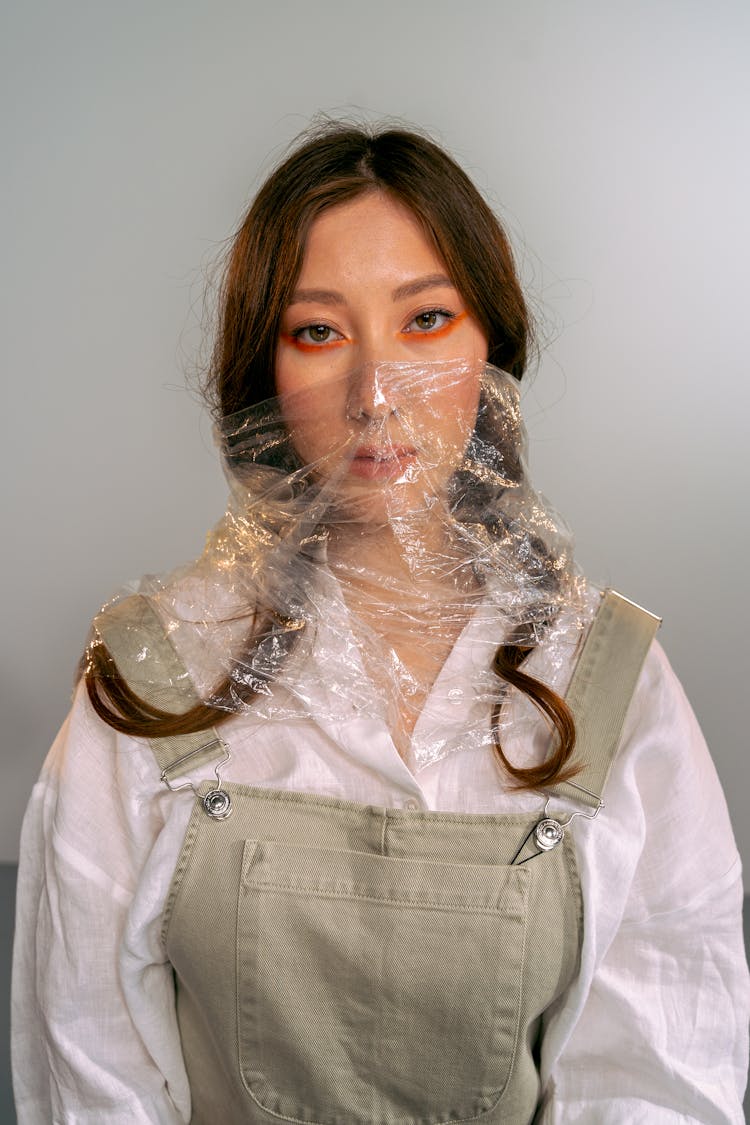 Woman With Her Face Wrapped In A Plastic Foil 