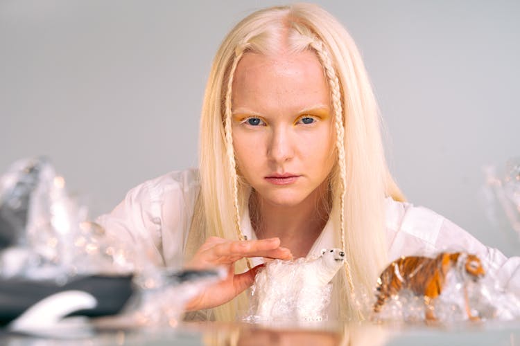 Portrait Of Albino Girl Playing With Toy Figurines