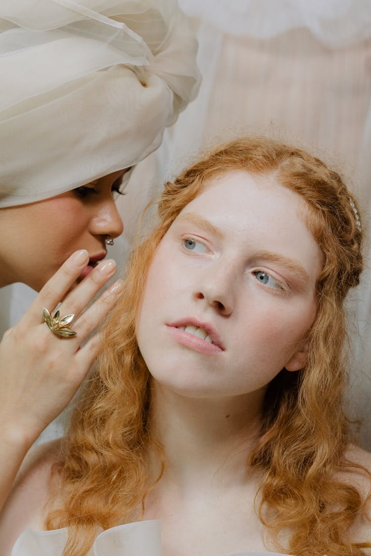 A Close-Up Shot Of A Woman Whispering To Another Woman