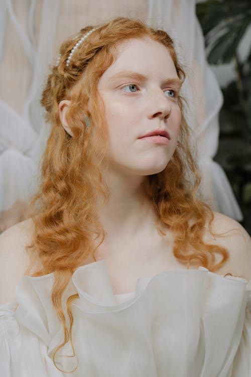 A Close-Up Shot of a Woman Wearing a Sheer Off Shoulder Top