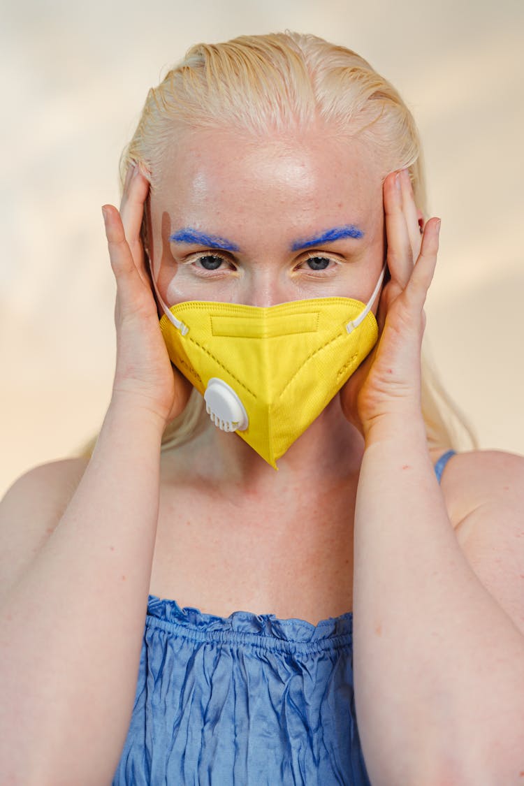 Portrait Of Woman With Blue Eyebrows Wearing Yellow Face Mask