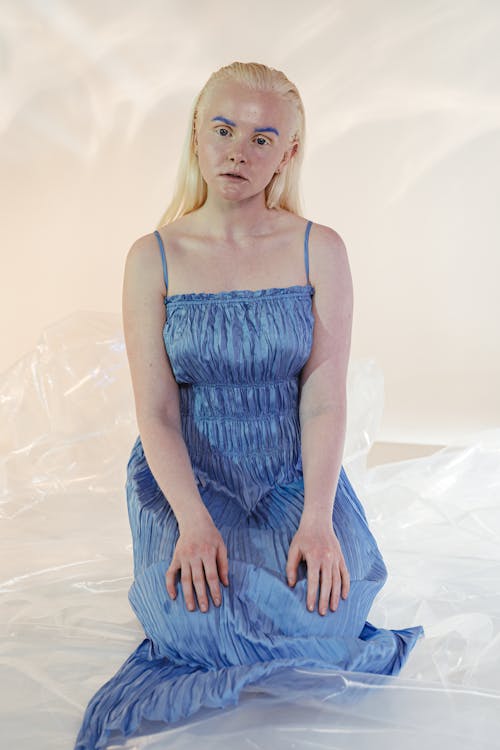 Woman in Blue Dress Sitting on the Floor with Plastic Wrap