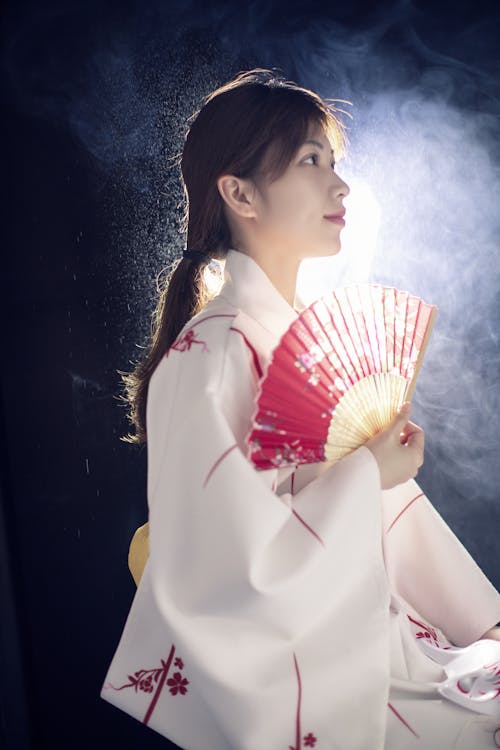 Woman in White Kimono Holding a Hand Fan