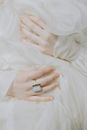 Person Wearing Silver Ring on White Textile