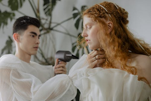 Man Drying Womans Hair with a Hairdryer 