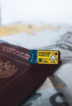 A Russian passport with an 'Adventure Awaits' pin symbolizes travel and exploration.