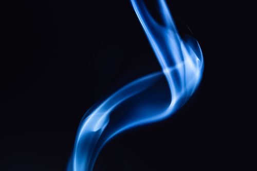 Free Curved blue smoke art over a black backdrop, showcasing fluid motion and elegance. Stock Photo