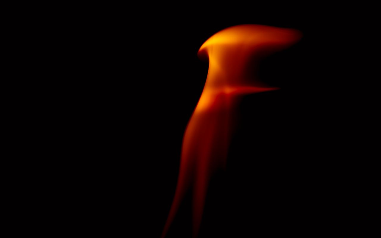 abstract close up of a flame with vibrant colors against a dark backgr