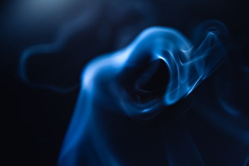 Free Captivating abstract image of blue smoke swirling in the dark, perfect for artistic backgrounds. Stock Photo