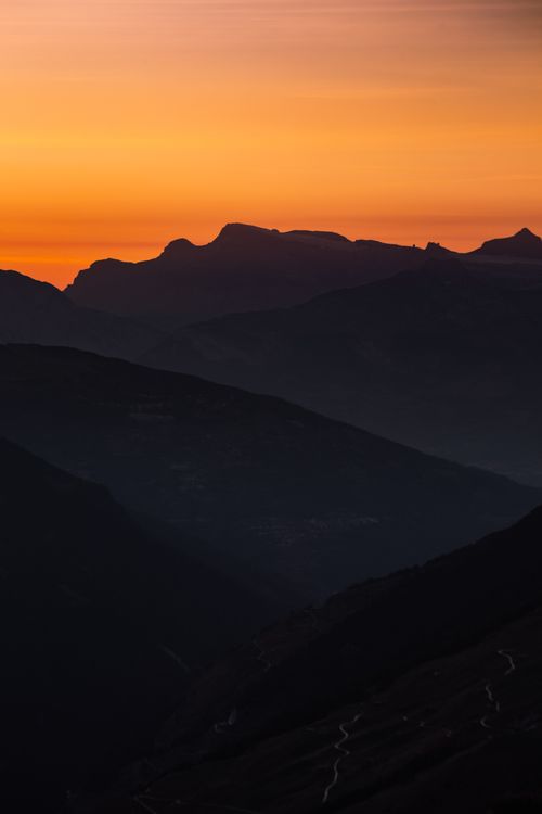 Free Silhouetted Swiss mountains at sunrise with vivid sky hues. Stock Photo
