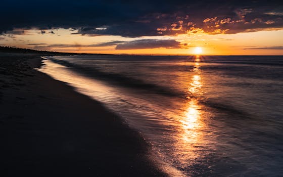 Stunning sunset over a calm Polish beach with golden reflections on the water.